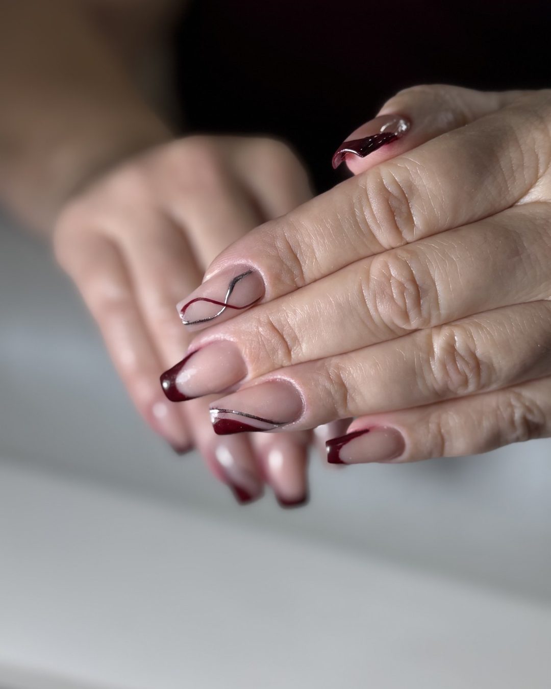 Unhas nude com nail art em bordô feitas no Stefany Concept